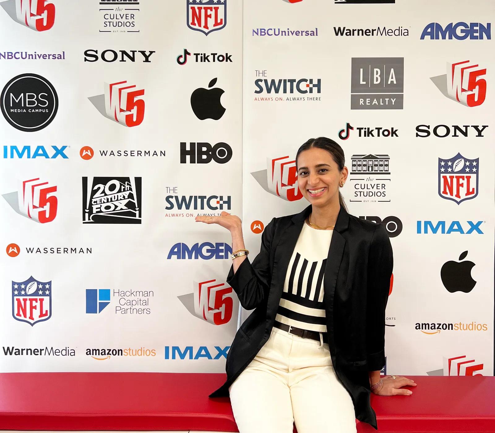 Apurva Purandare smiling in front of the Gensler Media photo booth.