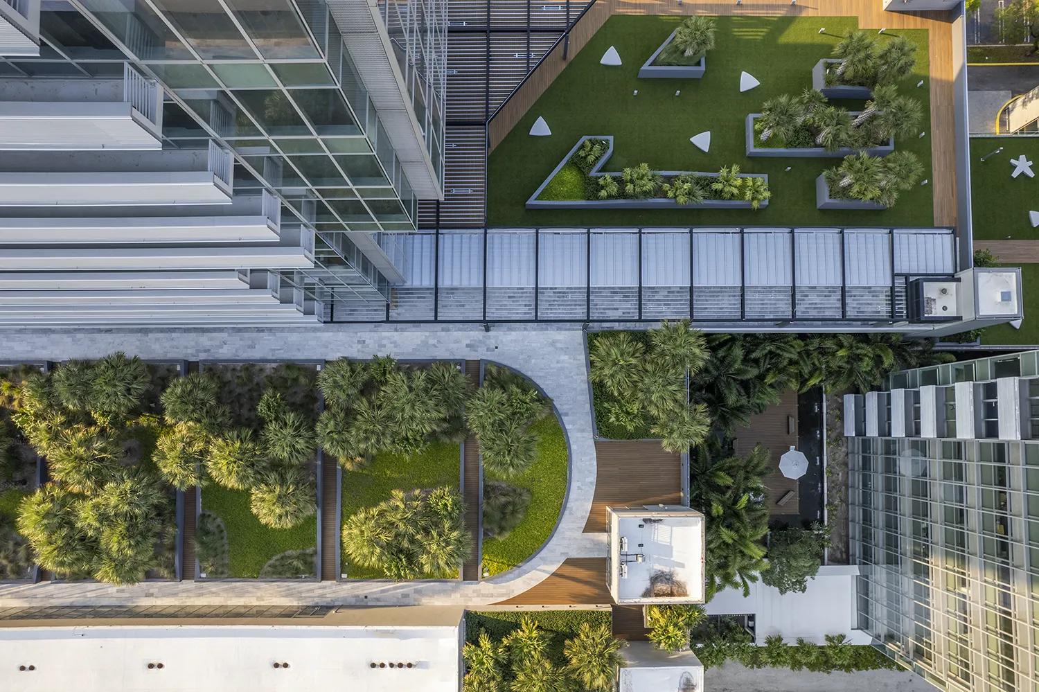 Overhead view of office building with recreational areas with grass and trees.