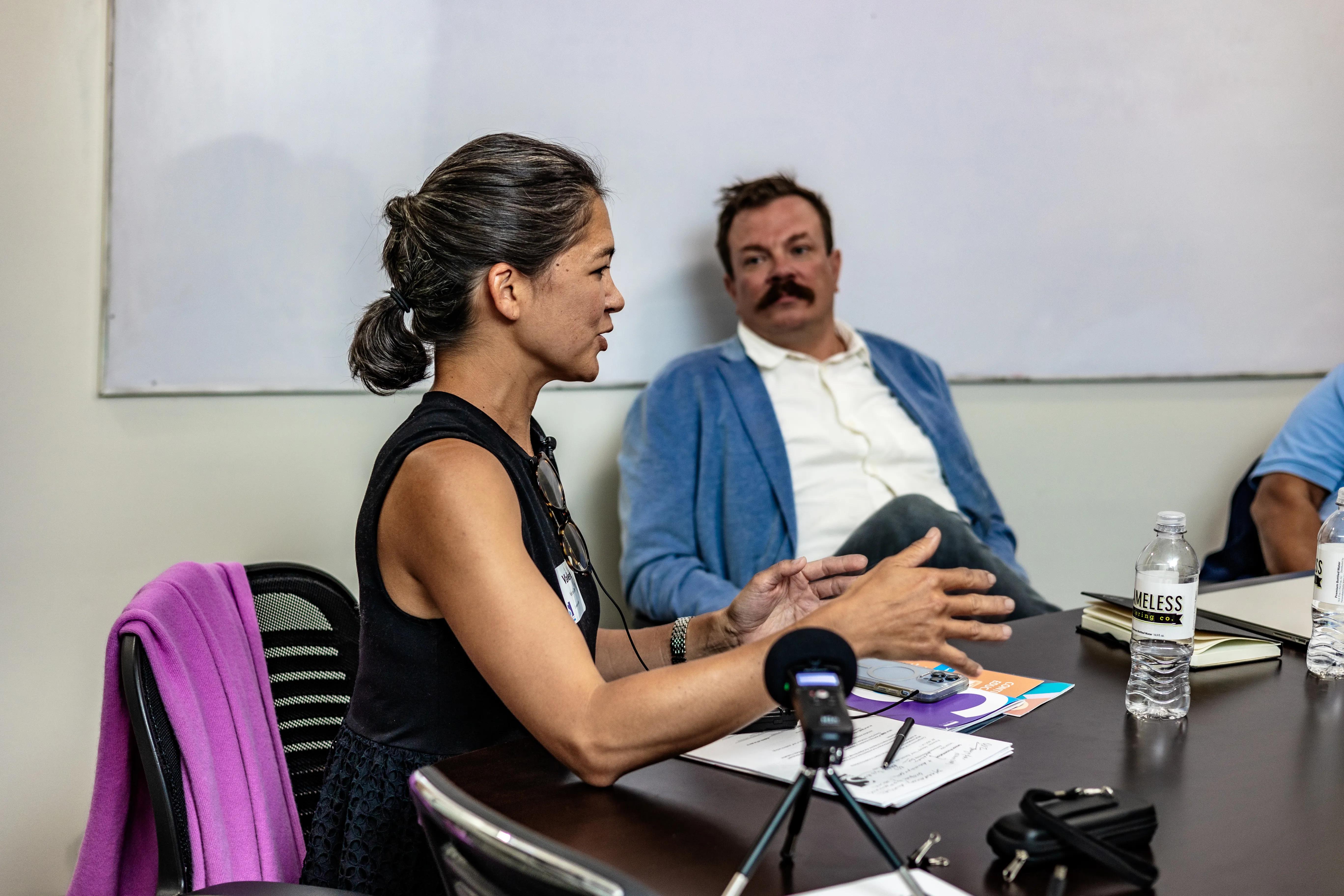 A woman speaks to other Scholars attendees in a conference room. 